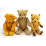 Three vintage teddy bear's including a straw filled example, all with jointed limbs and beaded eyes,
