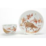 Chinese porcelain tea bowl and saucer, hand painted in iron red and gilded with a figure and water