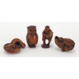 Four Japanese carved boxwood netsukes including one of a worker, two with character marks, the