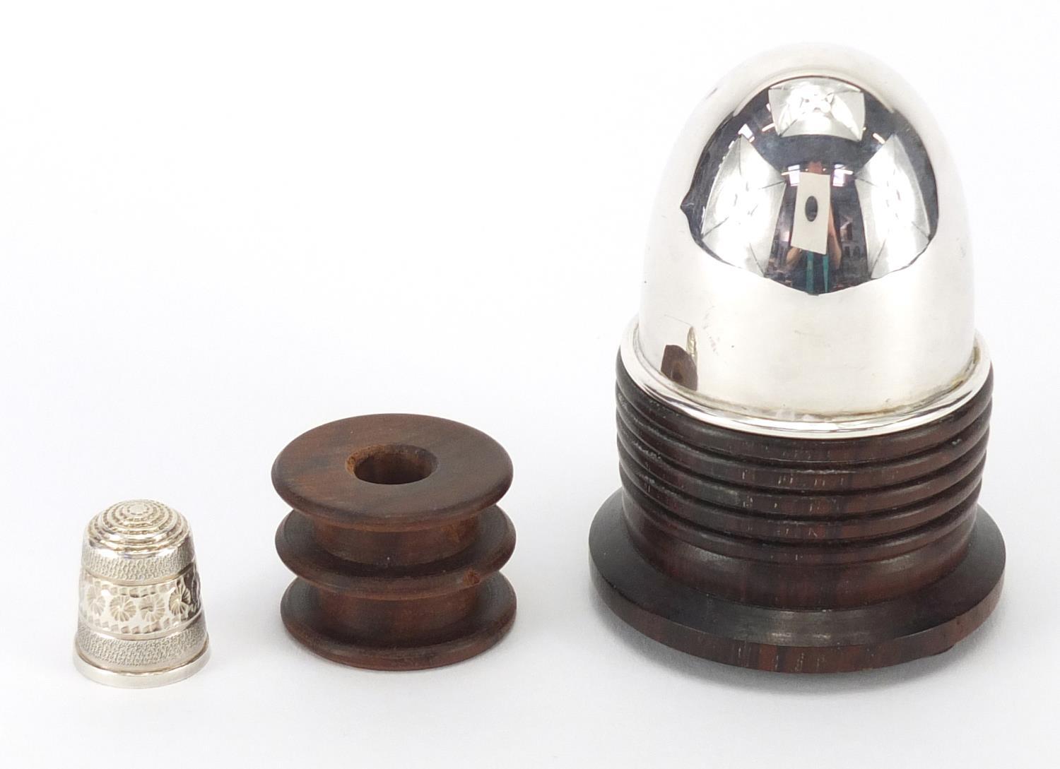 Sewing interest silver topped Lignum vitae cotton reel stand, with thimble, Birmingham 1989, 8cm