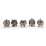 Indian five piece silver coloured metal cruet set, each embossed with figures, animals and