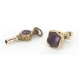 Two antique gold coloured metal watch keys, the largest with Intaglio amethyst seal, 2.5cm in