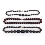 Three cherry amber coloured bead necklaces, the largest 50cm in length, approximate weight 143.