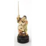 Japanese part stained carved ivory Okimono of a fisherman, on carved wood stand, character marks