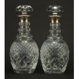 Pair of cut glass decanters with silver collars, indistinct London hallmarks, each 29.5cm high : For