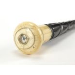 Ebonised walking cane with ivory handle having an inset compass, 87cm in length : For further