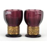 Pair of Mosser purple glass goblet vases, each with a gilded band depicting Grecian warriors,