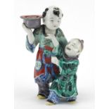 Chinese porcelain figural candlestick, modelled as a father and child, hand painted in the famille