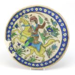 Large circular Iznik pottery tile, hand painted with a warrior on horseback, 36cm in diameter :