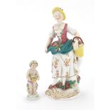 Hand painted porcelain figure of a girl holding a basket together with a cherub example, the largest