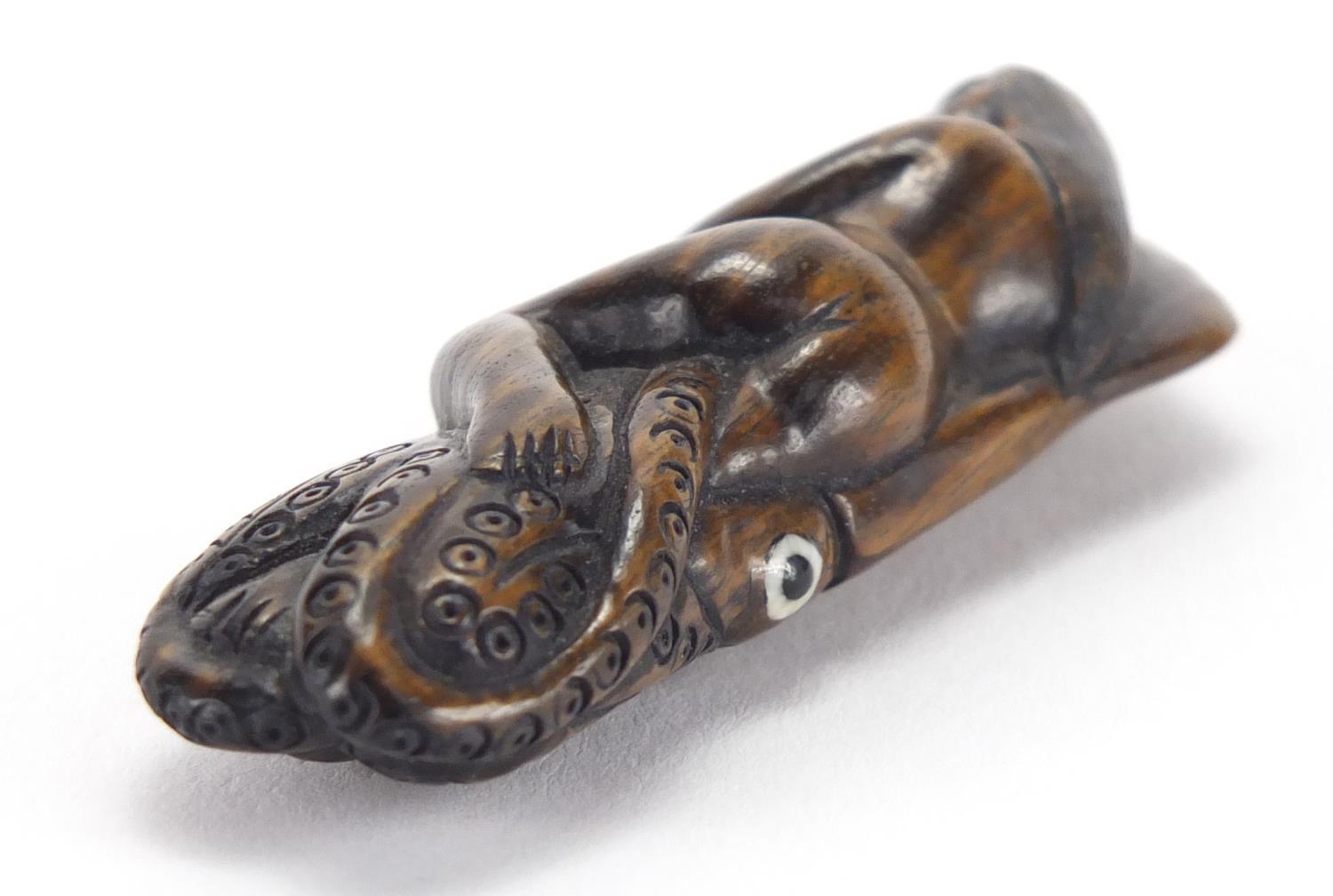 Japanese carved hardwood Netsuke of a female sleeping upon an octopus, with inset ivory character - Image 3 of 5
