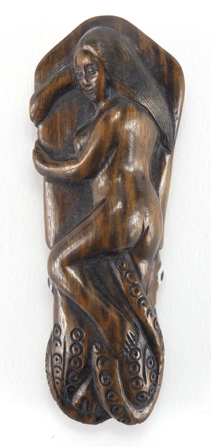 Japanese carved hardwood Netsuke of a female sleeping upon an octopus, with inset ivory character