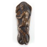 Japanese carved hardwood Netsuke of a female sleeping upon an octopus, with inset ivory character