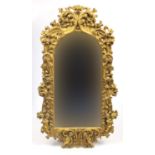 Ornate gilt framed bevelled edge mirror, decorated with putti amongst flowers, 121cm H x 67cm W :