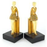 Pair of Art Deco style bookends, each modelled with an ivorine female wearing a gold dress, each