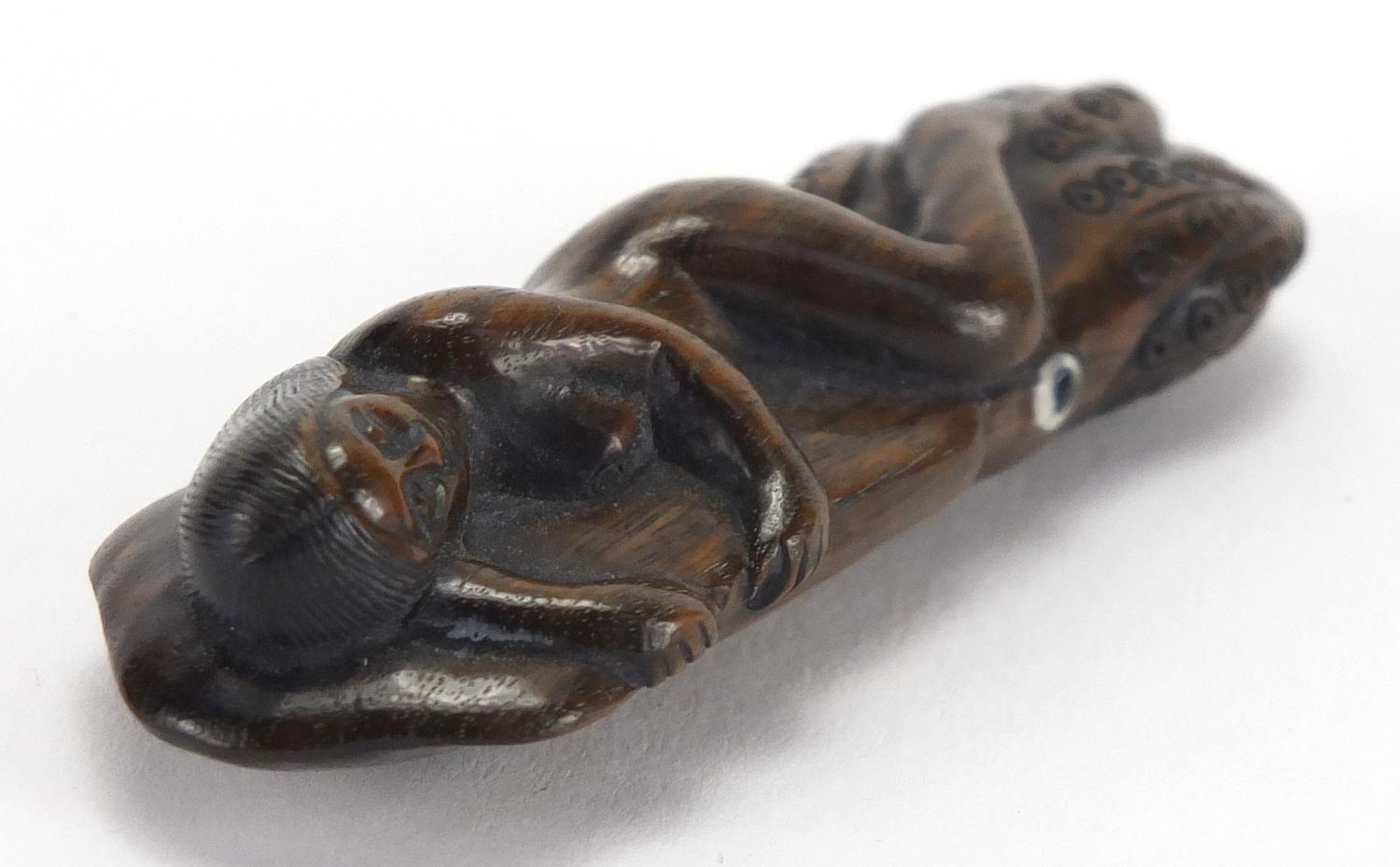 Japanese carved hardwood Netsuke of a female sleeping upon an octopus, with inset ivory character - Image 4 of 5