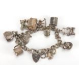 Silver charm bracelet with a selection of mostly silver charms including treasure chest, Buddha,