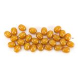 Loose amber coloured beads, each approximately 1.5cm in length, approximate weight 49.0g :For