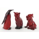 Three Royal Doulton Flambe animals comprising a cat, penguin and puppy, factory marks to the