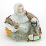 Chinese porcelain figure of Buddha holding a sack, finely hand painted in the famille rose