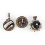 Three Victorian Scottish agate and gilt metal mourning pendants and brooches, one with serpent