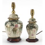 Two Japanese Satsuma jar and cover lamp bases, on hardwood stands hand painted with flowers, the