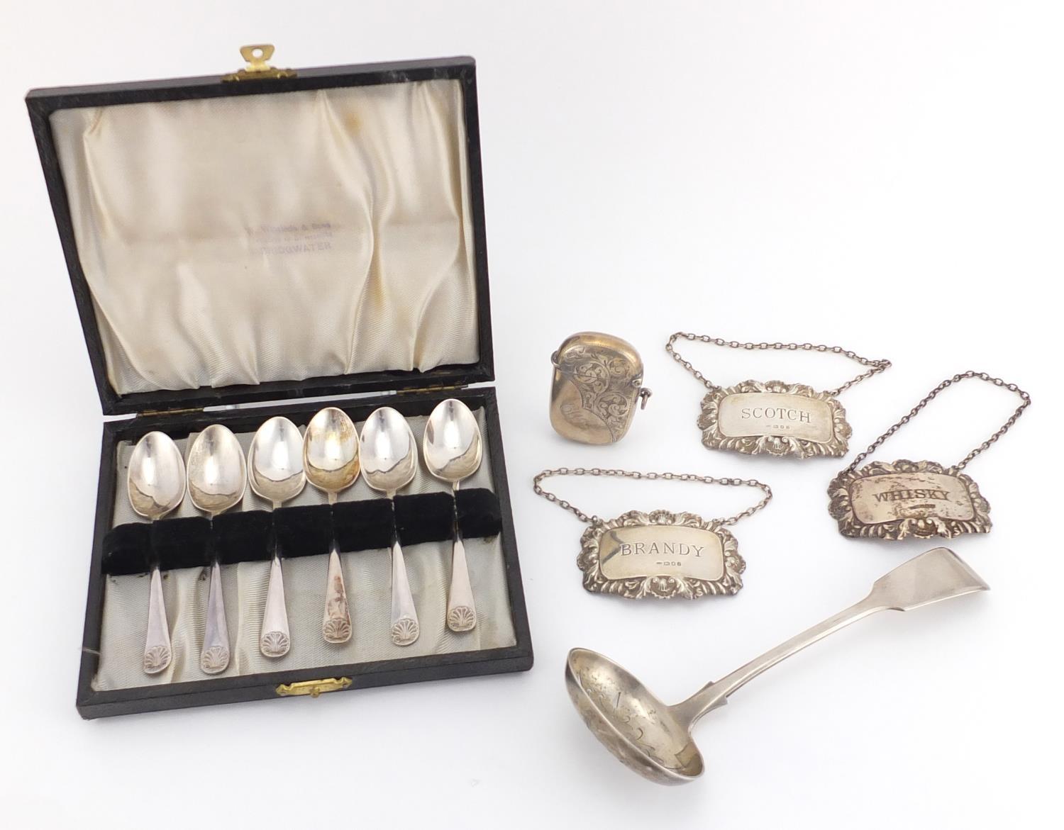 Silver items including a Victorian straining spoon, three decanter labels, a vesta and set of six