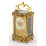 Gilt brass carriage clock with foliate blind fret panel, the enamelled chapter ring with Arabic