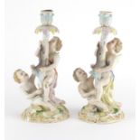 Pair of 19th century continental porcelain candlesticks, each modelled with two young boys and an