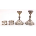 Pair of silver dwarf candlesticks and a pair of circular silver napkin rings, the candlesticks 11.