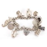 Silver charm bracelet with a selection of mostly silver charms including Dumbo, windmill,