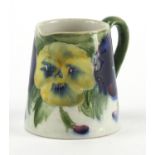 Early miniature Moorcroft jug with tapering body, hand painted in the Pansy pattern, impressed and