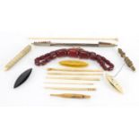 Sewing items and a string of cherry amber coloured beads including carved ivory and bone needle