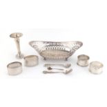 Silver items comprising an oval basket, miniature bud vase, four napkin rings and spoons, various