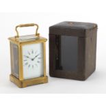 Gilt brass carriage clock with enamelled dial, Roman numerals and velvet lined case, the back