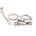 Silver and white metal jewellery including a bangle with floral chased decoration, charm bracelet
