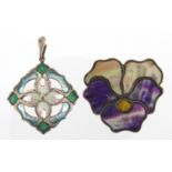 Two Art Nouveau silver brooches including an enamelled flower head example, both with indistinct