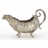 French silver sauce boat, profusely embossed with cherubs and flowers, raised on scroll feet,