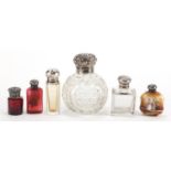 Six silver mounted scent bottles including a globular cut glass example and two faceted ruby
