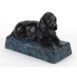 Stella Crofts pottery model of a recumbent spaniel, with a black and mottled blue glaze, incised