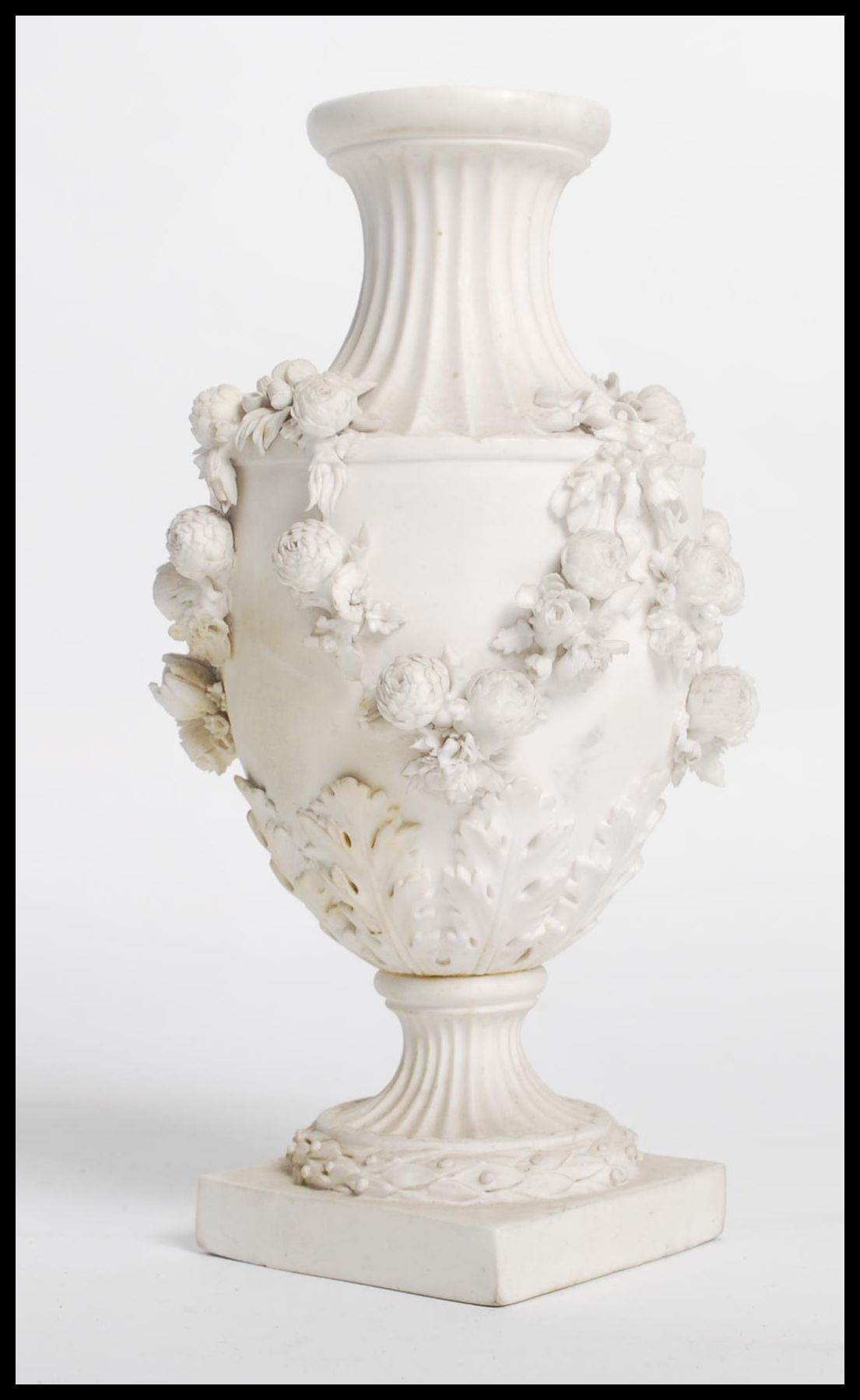 A 19th century Derby parian bisque ware vase raised on a square base with relief decoration of
