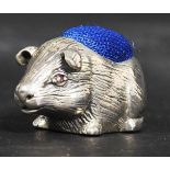 A sterling silver pin cushion in the form of a guinea pig having a blue pin cushion atop in the