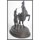 An early 20th century spelter figurine group depicting a Marley horse and tamer raised on a circular