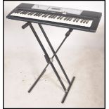 A Yamaha YPT-200 digital keyboard with original black metal stand, power cables and accessories.