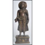 A 19th century Chinese bronze figurine of a standing Buddha raised on a pedestal base with relief