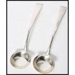 A pair of early 19th century Georgian silver hallmarked sauce ladles in the old English pattern.