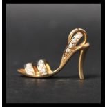 A hallmarked 18ct gold and diamond charm in the form of a stiletto shoe set with 17 diamonds to