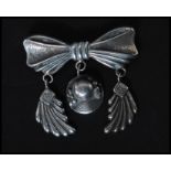 A sterling silver 925 stamped vintage brooch in the form of a bow with feather and roundel drops.