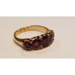 An 18ct antique garnet stone and diamond 5 stone ring. The large garnet stones with diamond spacers.