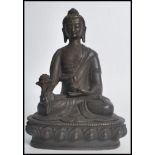 A 19th century Oriental Chinese bronze figurine of a Buddha in the lotus position raised on a